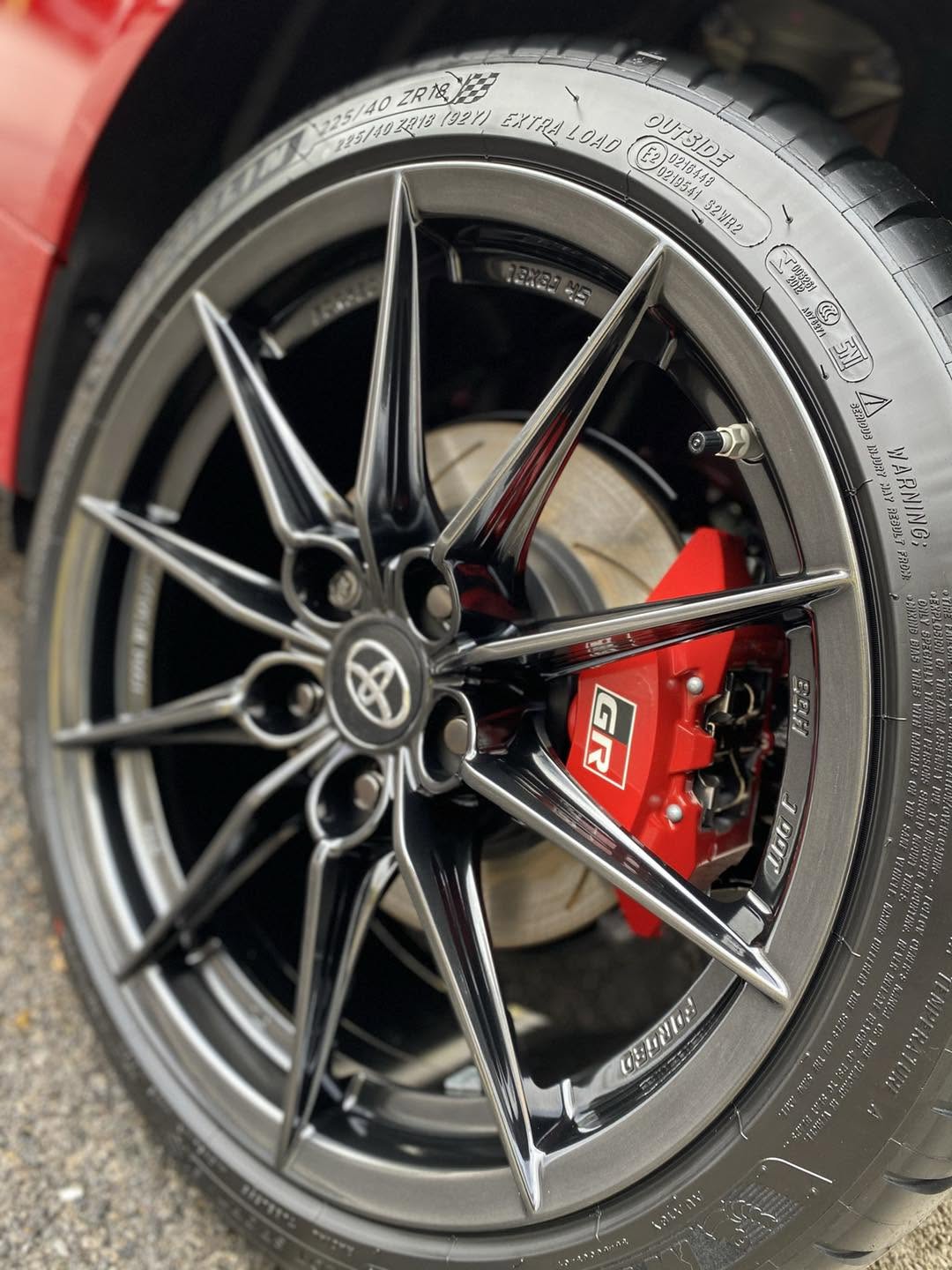 Toyota GR alloy wheel and red brake caliper after detailing