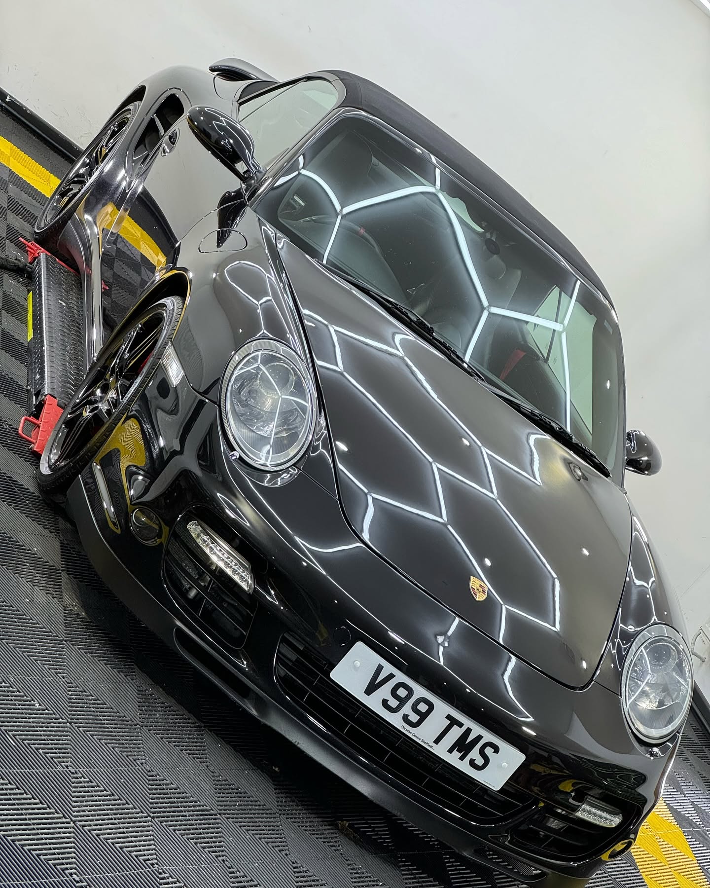 Black Porsche 911 with reflective paintwork in the JMM Detailing studio