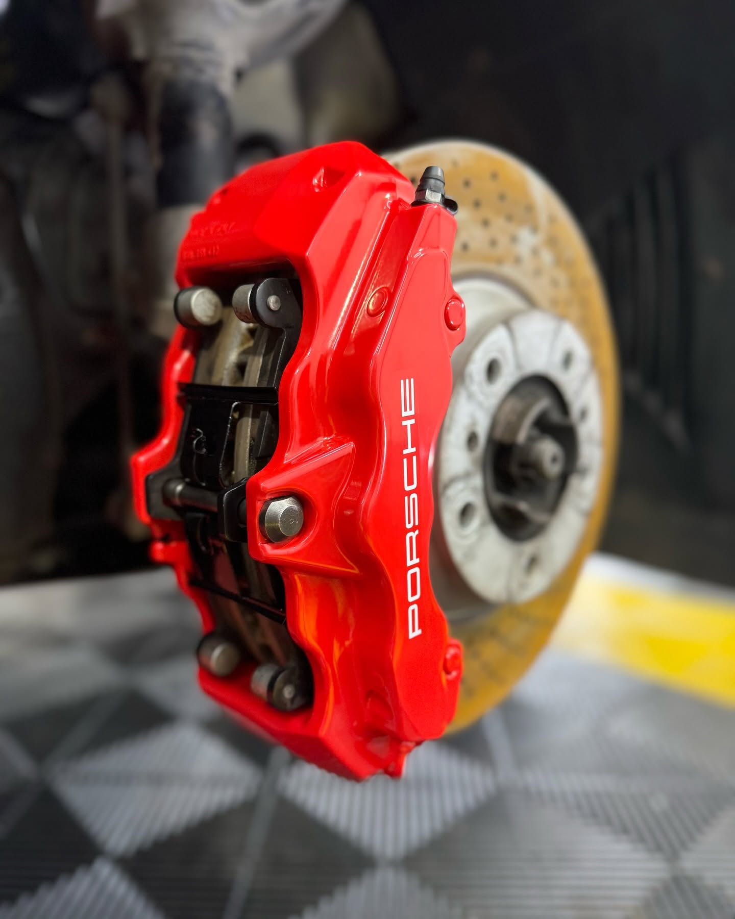Freshly detailed red Porsche brake caliper and disc